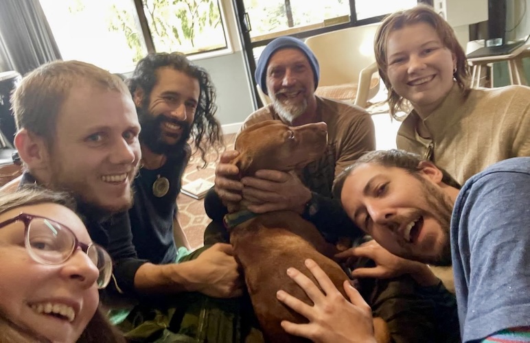 Group of people with a dog, embracing during the Momentum gathering