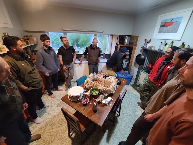 Group of men gathered around an indoor dining table